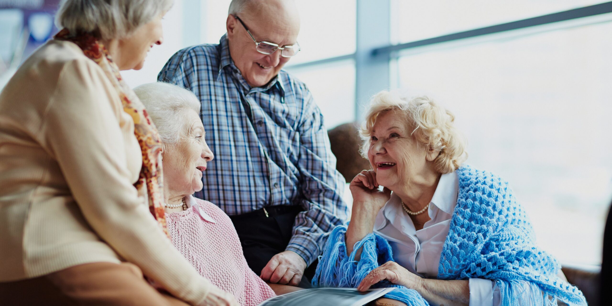 Older adults visit and look at book together