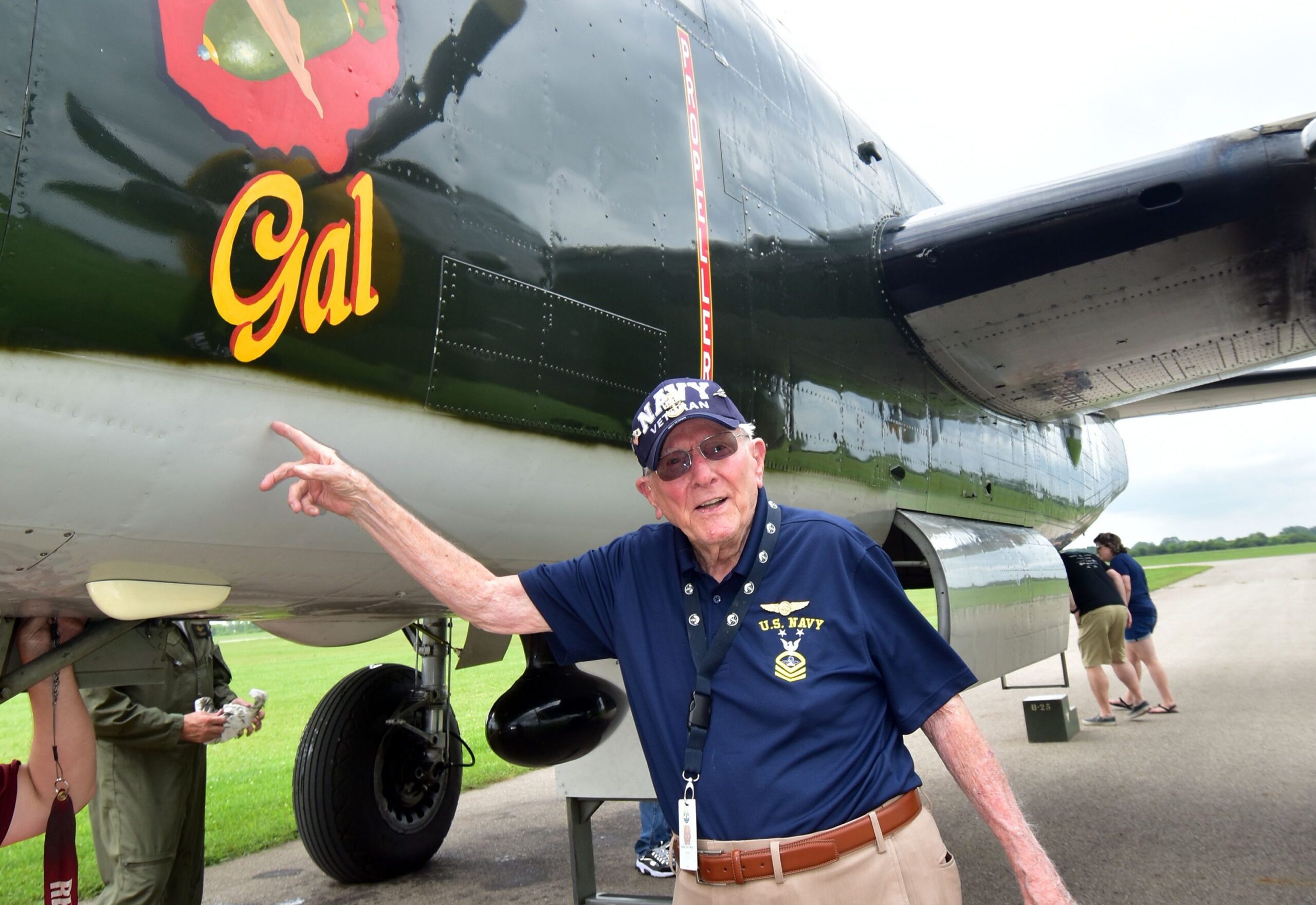 Older adult male points to old airplane