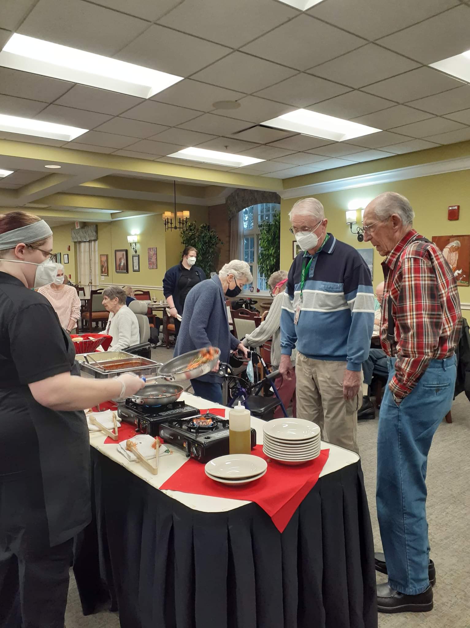 Residents dine at a pasta buffet in the dining room