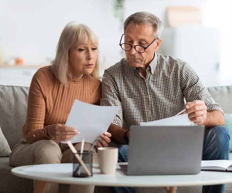 Senior couple reviewing documents on a couch